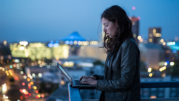 5G Solution, image of a girl holding phone in balcony with city view in background